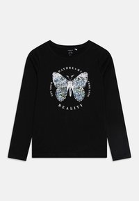 Camiseta negra de manga larga con un gráfico de mariposa de lentejuelas. El texto alrededor de la mariposa dice: "Deja que tus sueños diurnos se conviertan en realidad."