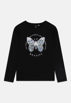 Camiseta negra de manga larga con un gráfico de mariposa de lentejuelas. El texto alrededor de la mariposa dice: "Deja que tus sueños diurnos se conviertan en realidad."
