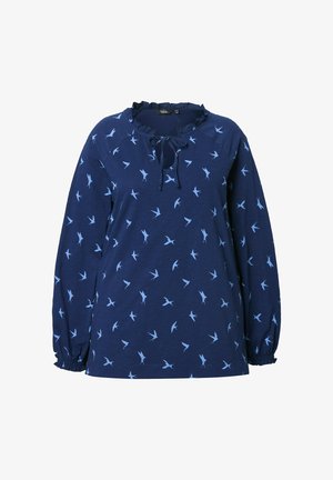 Granatowa koszula z długim rękawem, zdobiona falbaniastym dekoltem, z troczkiem i rozproszonym wzorem jasnoniebieskich ptaków. Miękka tkanina z marszczonymi mankietami.