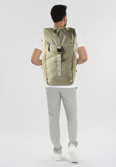 Zaino khaki con design a roll-top, hardware argentato e tasca anteriore con zip, realizzato in tessuto testurizzato e resistente.