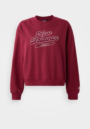 Karkasinis džemperis su apykakle, su baltu "New Balance" logotipu ir tekstu "Athletics". Gofruoti rankogaliai ir apatinė dalis, minkšta medžiaga.