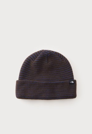Bonnet tricoté rayé marron foncé et bleu avec bord replié et petite étiquette noire avec le logo North Face sur le revers.