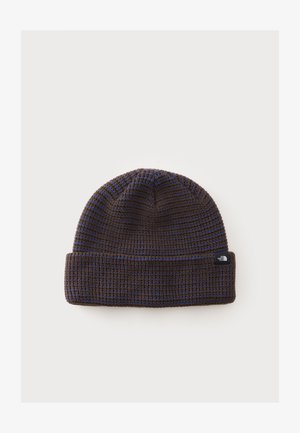 Bonnet tricoté rayé marron foncé et bleu avec bord replié et petite étiquette noire avec le logo North Face sur le revers.