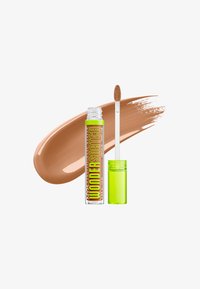 Tube ouvert de correcteur NYX Wonder Stick avec un bouchon vert citron et une baguette applicatrice devant un échantillon de maquillage liquide beige.