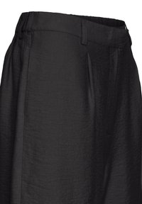Pantalon noir taille haute avec des plis, des passants ceinture et une texture de tissu mate et lisse.