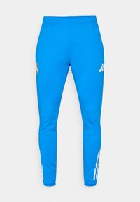 Blå sportbukser med elastisk talje, prydet med et hvidt adidas-logo og et Real Madrid-emblem. Glat tekstur og slim fit design.