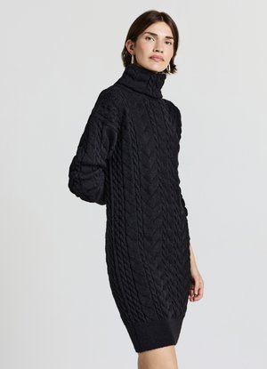 Vestito nero lavorato a maglia con collo alto a risvolto, caratterizzato da un motivo a treccia testurizzato e polsini a coste, che offre una vestibilità ampia e rilassata.