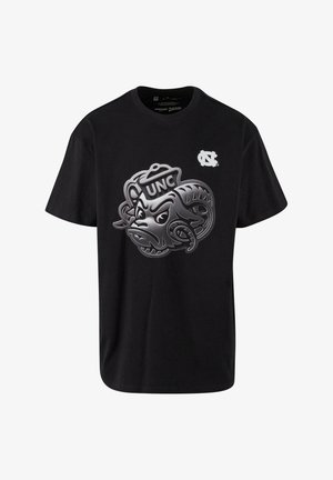 Juodas trumpomis rankovėmis marškinėliai su ryškiu metaliniu pilku UNC logotipu ir agresyvaus mastrono dizainu. Klasikinio apvalaus kaklo stiliaus.