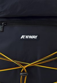 Dunkelblauer Rucksack mit strukturierten Oberflächen, der ein K-Way-Logo, einen Reißverschlussverschluss und bunte elastische Kordeln zur Anpassung und zum Styling bietet.