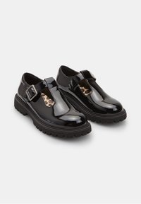 Zwarte lakleren schoenen met een uitsnijdontwerp, voorzien van een zijgesp en een textuur rubberen zool. Gevoerd met een leopardi printstof.