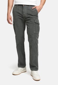 Grå kordfløjls cargo bukser med sidelommer, lige snit og tekstureret finish, parret med hvide sneakers.