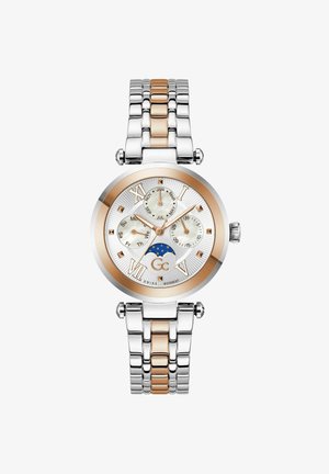 Reloj de metal plateado y oro rosa con una esfera redonda, un dial blanco texturizado, indicadores en números romanos y tres sub-diales. Presenta un diseño de fase lunar.