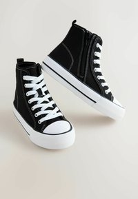 Mustad kõrge säärega tennised, valmistatud lõuendist, millel on valged paelad, kummist tallad ja kontrastsed õmblused, küljepealse luku detailiga.