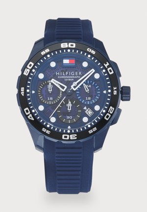 Montre-bracelet chronographe Tommy Hilfiger bleue avec lunette noire, marqueurs blancs, trois sous-cadrans, fenêtre de date à 4 heures et bracelet en silicone strié.