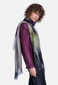 Sciarpa leggera e multicolore con motivi astratti, caratterizzata da tonalità di verde, grigio e nero. Texture morbida con bordi sfrangiati.