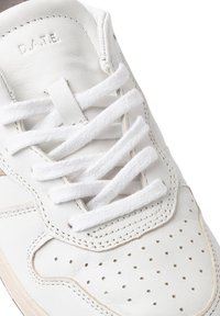 Baskets en cuir blanc avec bout rond, surface texturée, lacets blancs plats et détails perforés sur le capuchon du orteil. Logo de la marque embossé.