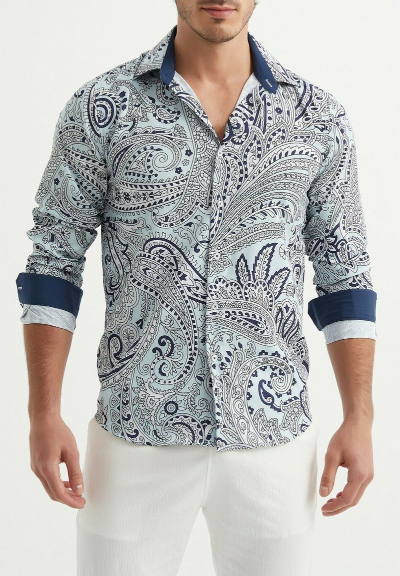 Chemise bleu clair à manches longues avec un motif paisley bleu marine. Col et poignets bleu marine contrastants, avec un tissu texturé et un design à boutons sur le devant.