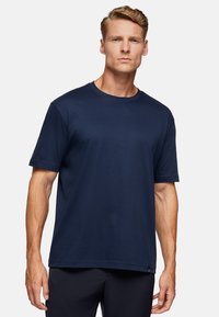 Navy blue short-sleeve T-shirt made of soft, smooth fabric with a round neckline and relaxed fit. Features a subtle logo detail at the hem.