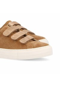 Baskets en daim marron avec trois bandes Velcro, détails perforés et semelle en caoutchouc blanc texturé. Bout rond et design décontracté.