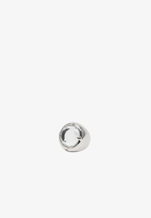 Anillo de plata con una gran gema clara facetada, montada en una banda suave y redondeada. Acabado elegante y pulido con engastes de garra visibles.