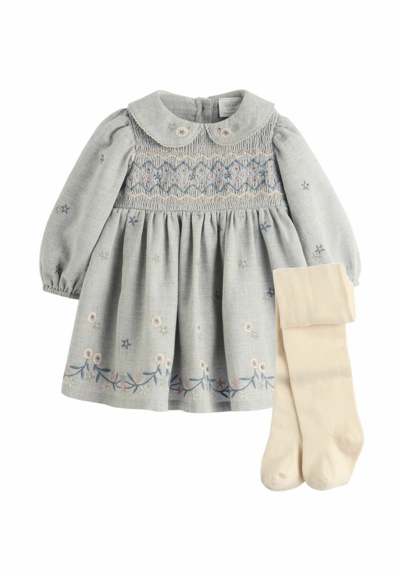 Robe bébé gris clair à manches longues, broderie florale, corsage smocké, col Claudine, associée à des collants couleur crème.