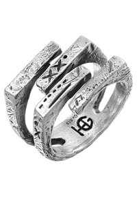 Bague en argent présentant un design abstrait avec des surfaces texturées et inégales, et des barres rectangulaires qui se chevauchent. Marquée d'un logo à l'intérieur.