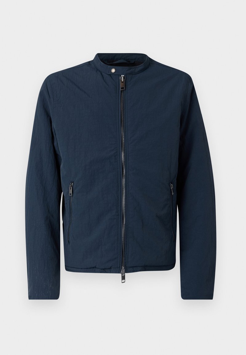 Veste légère bleu marine avec un col haut, fermeture éclair à l'avant et deux poches latérales. Elle présente un tissu texturé pour un look décontracté.