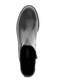 Zwarte leren enkelboot met ronde neus, gladde textuur, decoratieve stiksels en een lage, gestructureerde zool. Voorzien van een zijrits voor eenvoudig aan- en uittrekken.