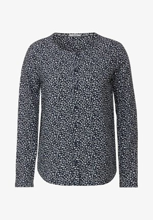 Pitkähihaista puseroa tummansinisenä, jossa on geometrinen valkoinen kuvio. Ominaisuuksiin kuuluu pyöreä pääntie, nappiaukko ja sileä kankaan pinta.