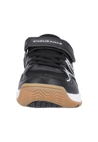 Svart sportskor med kardborreband, syntetiskt ovandelmaterial, vadderad krage, gummisula och vita samt gråa accenter på sidorna.