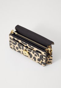 Leren portemonnee met luipaardprint in bruin en zwart, met een gouden ronde sluiting, voorzien van een ritsvak en een gestructureerd oppervlak.