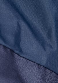 Tessuto blu navy, superficie testurizzata con una sezione liscia e leggermente ruvida, caratterizzata da tonalità di blu in contrasto in un design a strati.
