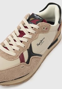 Μπεζ και καφέ αθλητικά παπούτσια με σουέντ και δερμάτινες λεπτομέρειες. Διαθέτουν λευκά κορδόνια, μαύρες και βουργουνδί λεπτομέρειες, και το λογότυπο Pepe Jeans στο πλάι.