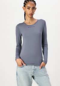 Long-sleeve, fitted top in slate gray with a rounded neckline and "BLANCHE" logo printed in black on the chest. Smooth fabric texture.