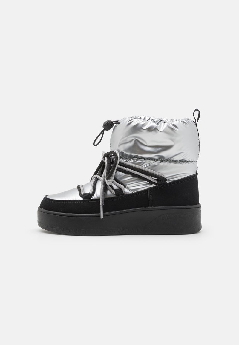 Silver and black ankle boot with a shiny, padded upper, featuring a cinched top, black suede accents, and a thick black platform sole.