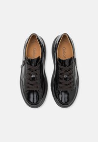 Schwarze Lacklederschuhe mit runder Zehe, Schnürung vorne und seitlichem Reißverschluss. Braune Schnürsenkel und Innenfutter; Gummisohle. Markenlogo sichtbar.