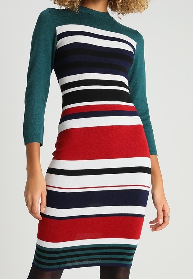 Stickad klänning med gröna långa ärmar, en figursydd silhuett och vertikala ränder i röd, vit, svart och blå över midjan.