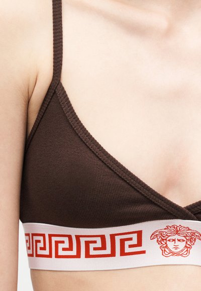 Καφέ ριμπ σουτιέν με λεπτές τιράντες και λευκή ελαστική λωρίδα με κόκκινο σχέδιο ελληνικού κλειδιού και έμβλημα κεφαλής Μήδεια.