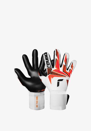 Gants de gardien en noir et blanc avec des accents orange et noir, prise texturée et sangles réglables au poignet. "SOYEZ CELUI" imprimé sur le poignet.