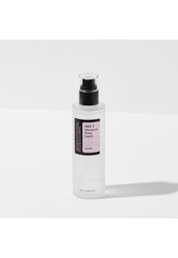 Bouteille transparente de 100 mL avec un bouchon-pompe noir et une étiquette violette, présentant un texte listant les détails du produit. Design simple et cylindrique.