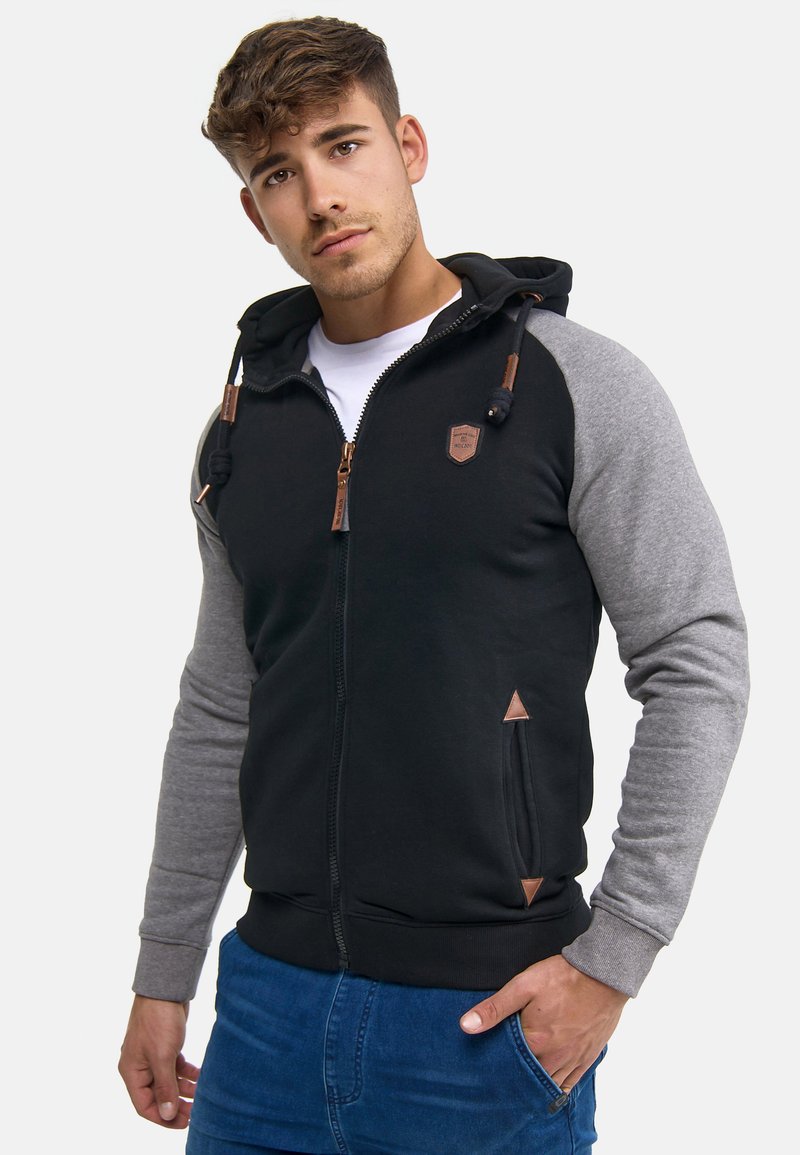 Sudadera con cremallera en negro y gris con un acabado texturizado, capucha con cordón, bolsillos en ángulo y detalles de cuero en la cremallera y los laterales.