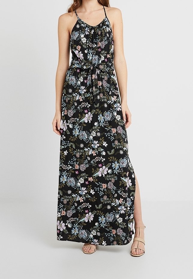 Robe longue noire à motif floral avec des fleurs bleues, roses et blanches. Bretelles spaghetti, ceinture à la taille et fente latérale. Tissu doux.