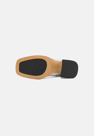 Talpa de pantof din piele maro cu toc din cauciuc negru și textură netedă. Designul are un vârf rotunjit și detalii minime.