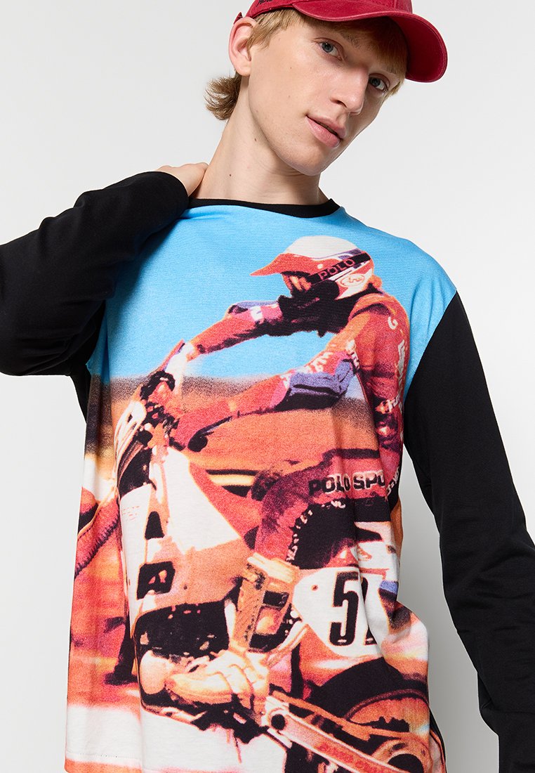 Langärmliges Hemd mit Blau- und Schwarzfarbschema, mit einem großen Motorradmotiv in lebhaften Rot- und Orangetönen. Weicher Stoff.