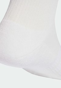 Bijela pamučna čarapa s rebrastom teksturom i ojačanim petom. Glatka površina i jednostavan dizajn, idealna za svakodnevno nošenje.