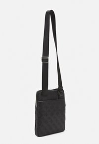 Černá crossbody taška s embosovaným vzorem. Vyrobena z texturovaného materiálu, má zipové uzavírání a nastavitelný popruh. Obdélníkový tvar.
