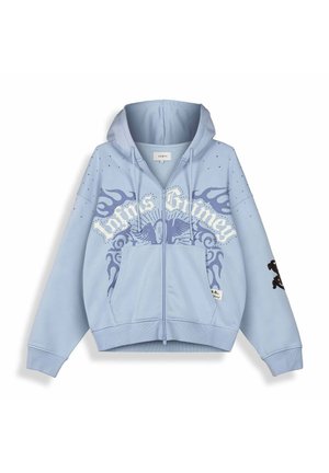 Hellblauer Kapuzenpullover mit Reißverschluss, Flügel-Emblem, Flammendesigns und dem Text "Trivia Grimey" über der Brust, dazu Fronttaschen und verstellbare Kapuze.