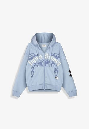 Sudadera con capucha azul claro con cremallera, con emblema de alas, diseños de llamas y texto "Trivia Grimey" en el pecho, además de bolsillos delanteros y capucha con cordón.