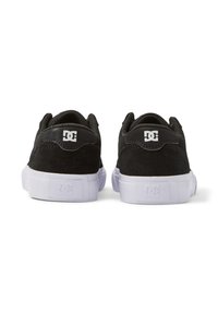 Pantofi de skateboard din sueding negru, cu o talpă din cauciuc albă. Au un guler și o limbă căptușite, și un logo pe călcâi și pe lateral.