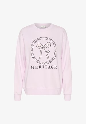 Hele roosa puuvillane sviiter, mille keskel on graafika kaare ja all tekst "HERITAGE". Lihtne disain ja mugav lõige.